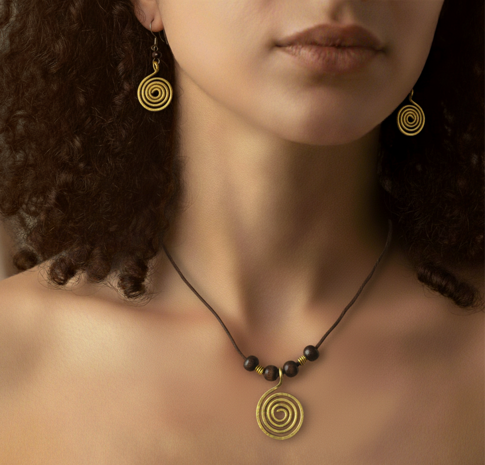 Close-up of a person wearing gold spiral earrings and a necklace with dark beads.