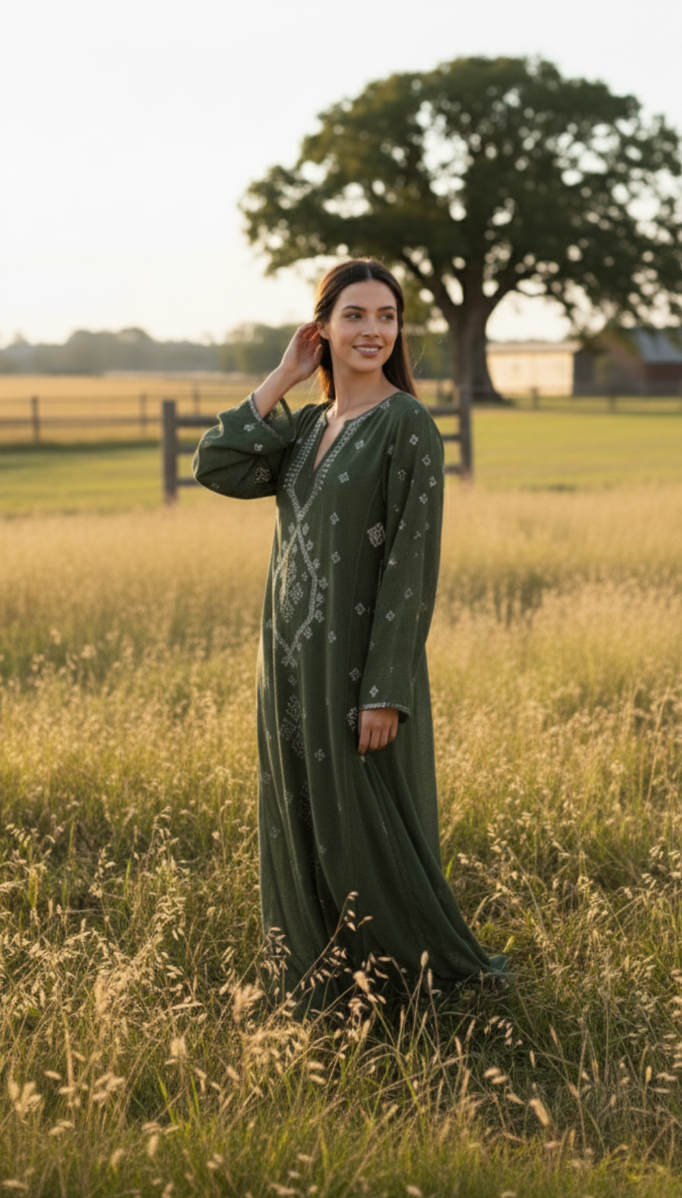 Woman in a green dress standing in a field with trees in the background