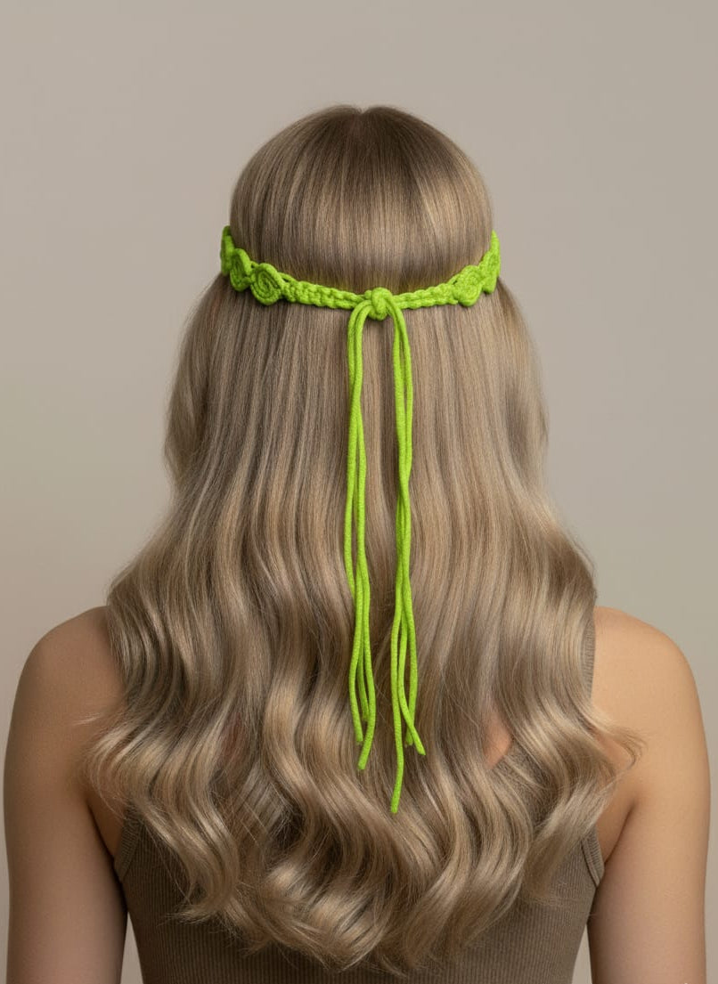 Person with long blonde hair wearing a green headband against a neutral background