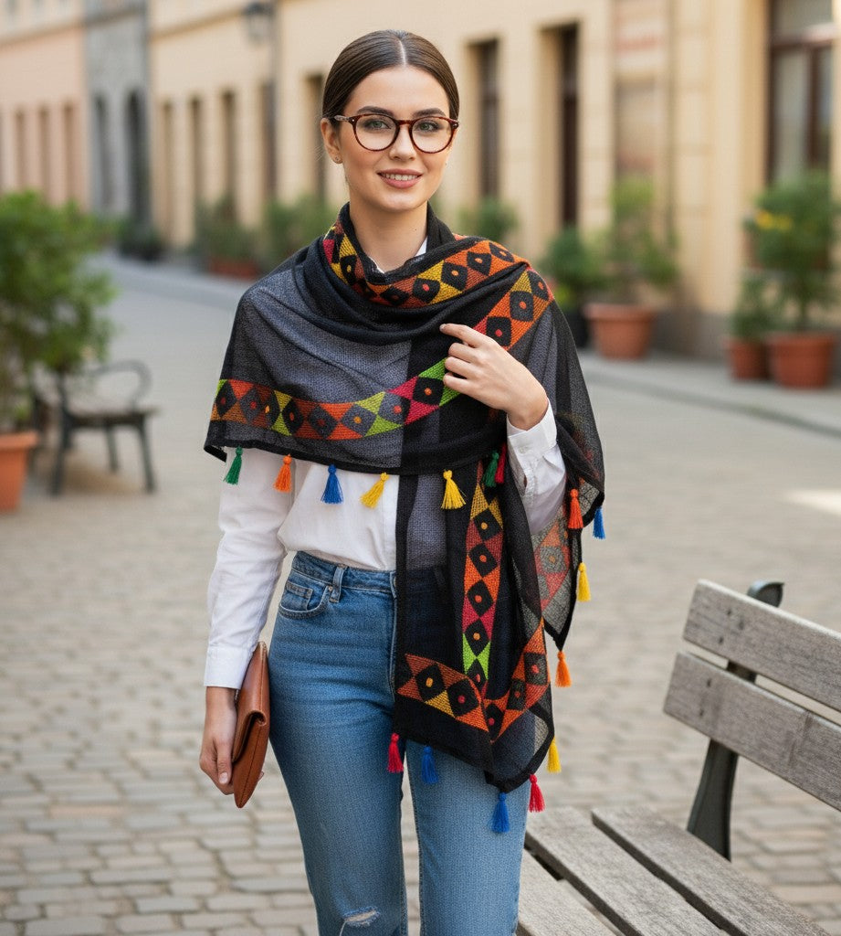 Woman wearing a colorful patterned scarf outdoors on a street.
