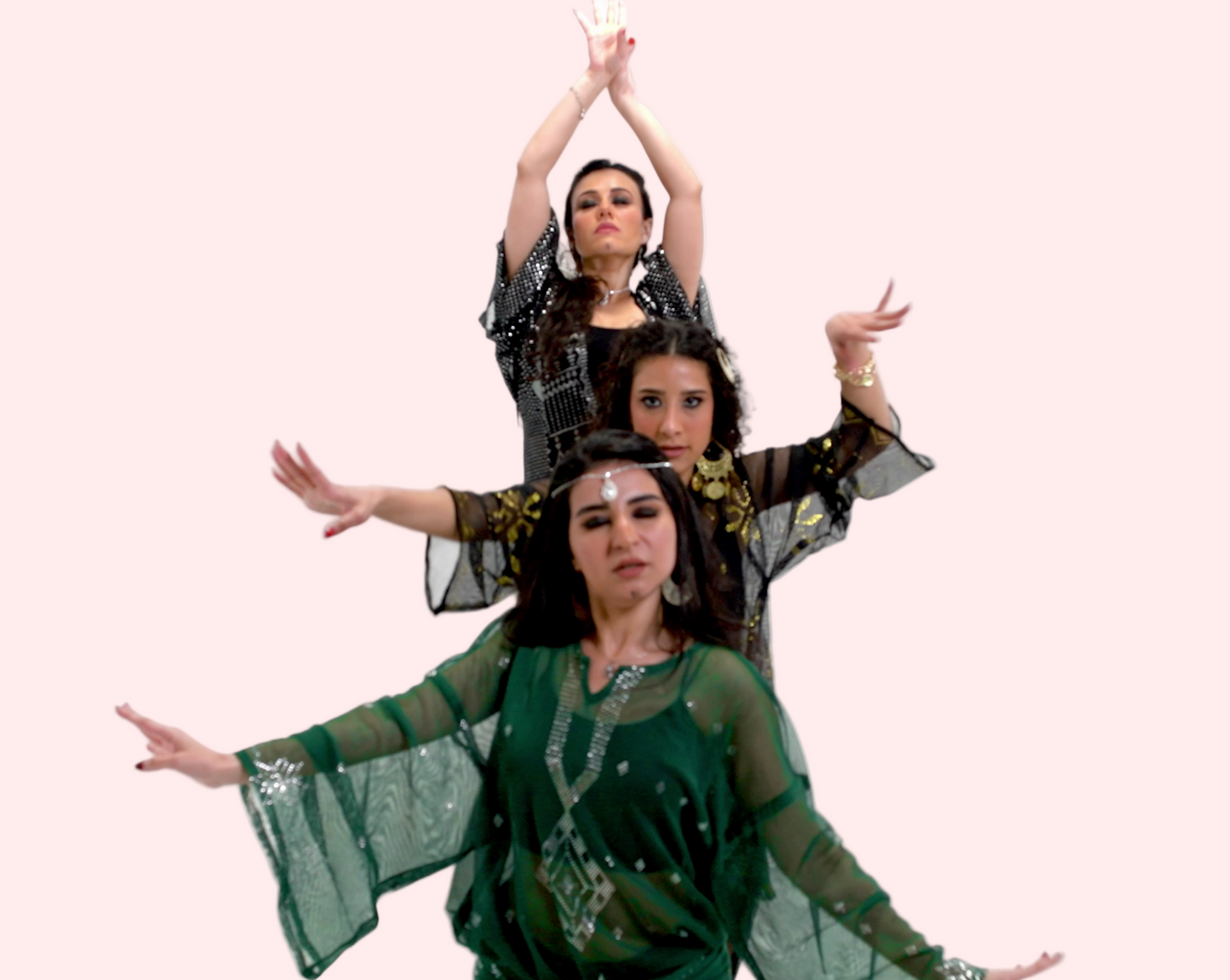 Three women in traditional attire posing against a white  background