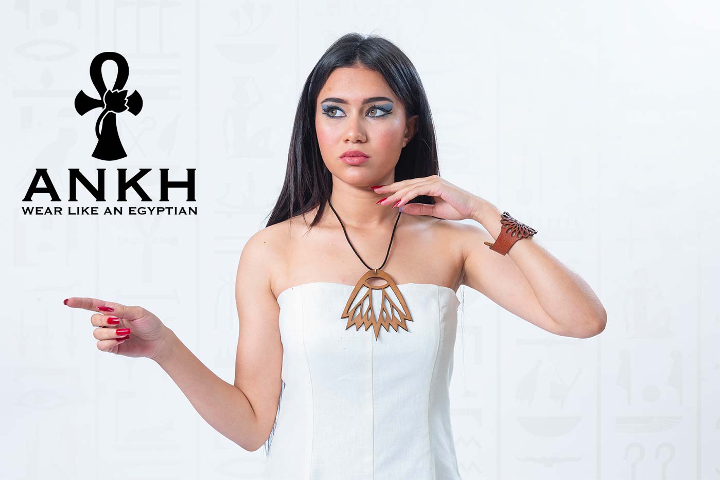 Woman wearing an elegant strapless linen dress adorned with an Ankh pendant necklace symbolizing life in ancient Egypt