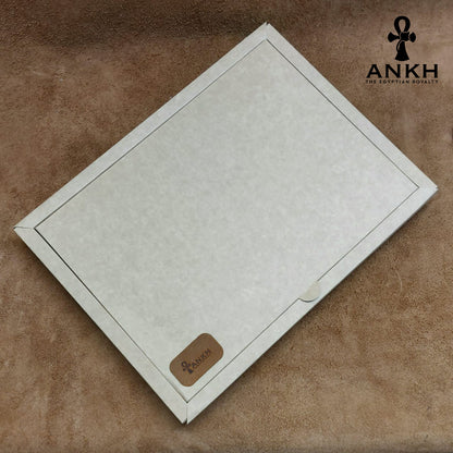 A white box containing four ANKH leather accessories: a passport cover with notebook, a key chain, a glasses cover, and a card holder, displayed on a textured surface. طقم هدية من الجلد الطبيعي الفاخر منقوش برمز العنخ المصري هدية من مصر