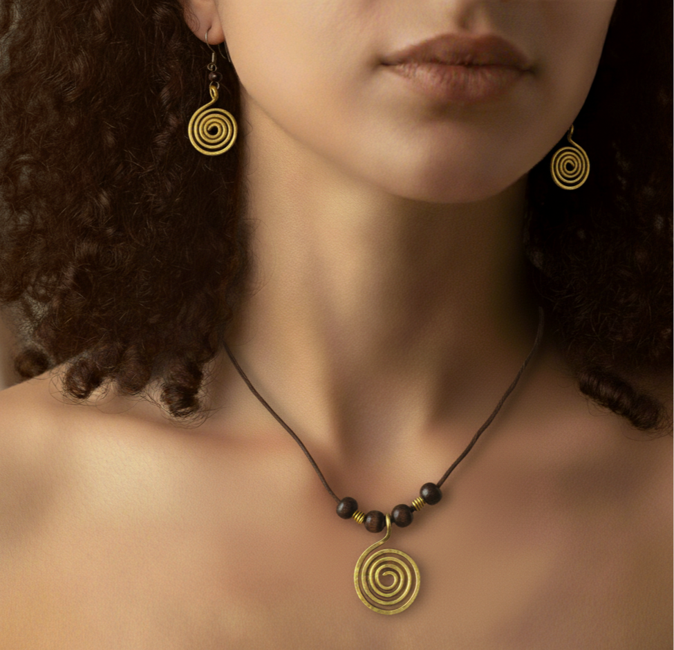 Close-up of a person wearing gold spiral earrings and a necklace with dark beads.