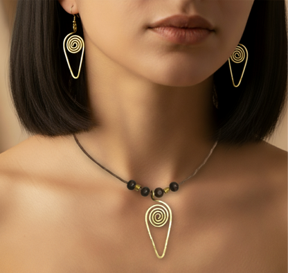 Close-up of a woman wearing gold spiral earrings and a matching necklace against a neutral background.