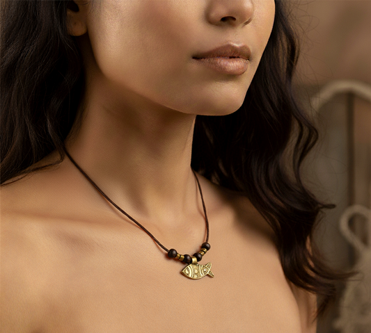 Necklace with a fish pendant worn by a person, with a blurred background
