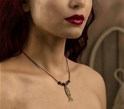 Close-up of a woman wearing a necklace with a pendant, blurred background