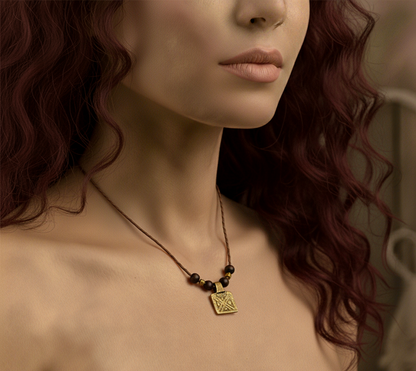 Close-up of a woman wearing a gold necklace with a square pendant.
