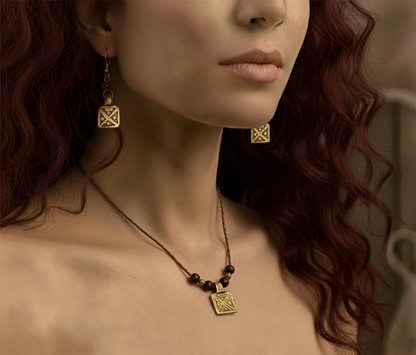 Close-up of a woman wearing gold earrings and a necklace with a neutral background