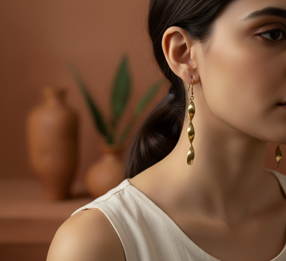 Close-up of a woman wearing gold earrings with a blurred indoor setting.