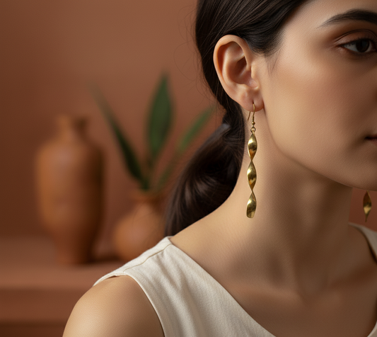 Close-up of a woman wearing gold earrings with a blurred indoor setting.