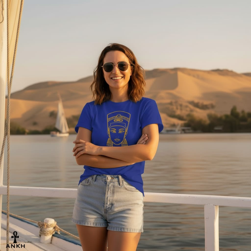 Woman in a blue t-shirt and denim shorts standing on a boat with a scenic background