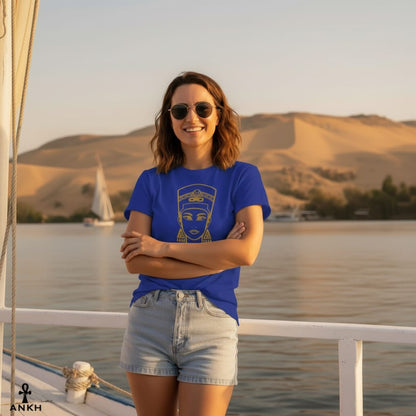 Woman in a blue t-shirt and denim shorts standing on a boat with a scenic background