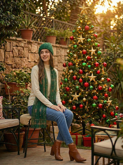 Woman sitting in front of a decorated Christmas tree outdoors.
