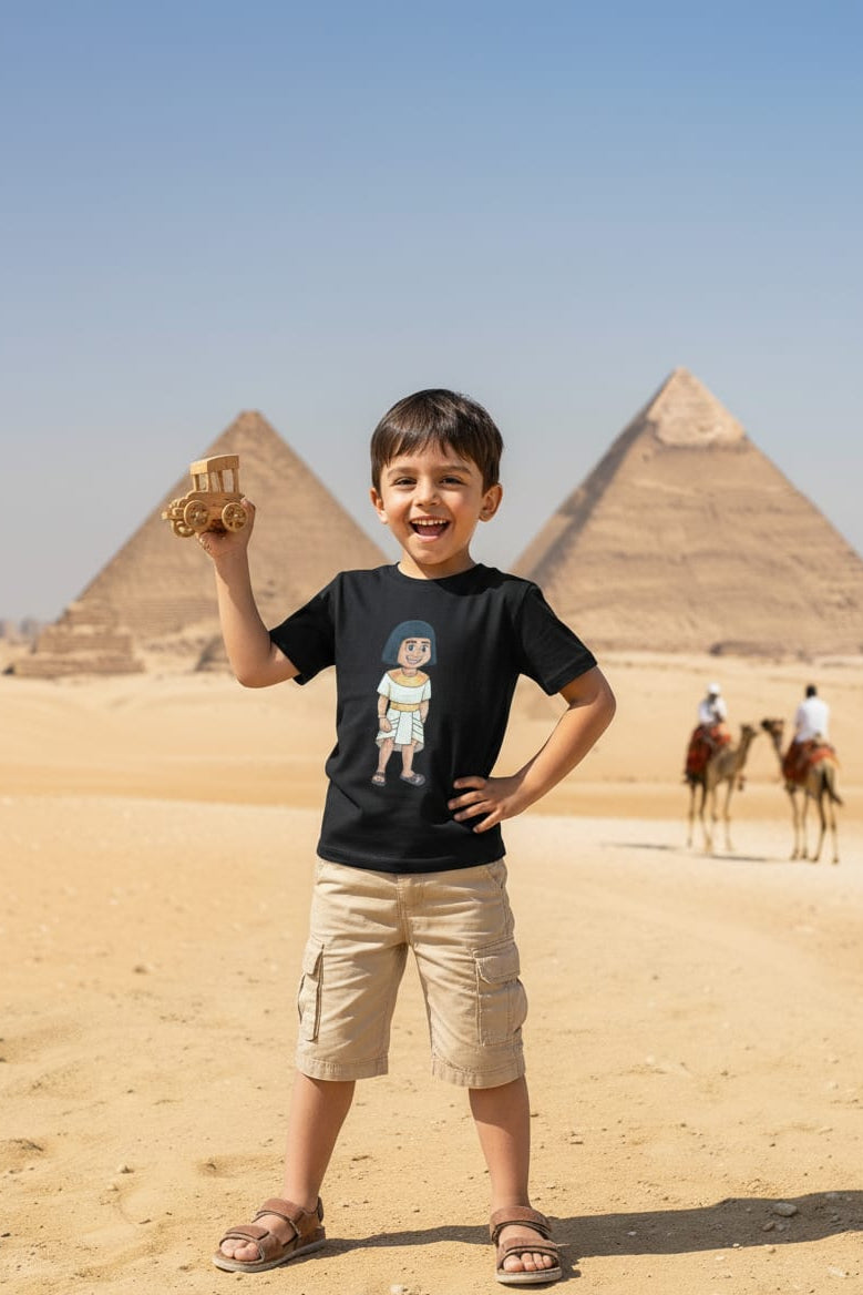 Child holding a toy pyramid in front of the pyramids of Giza with camels in the background.