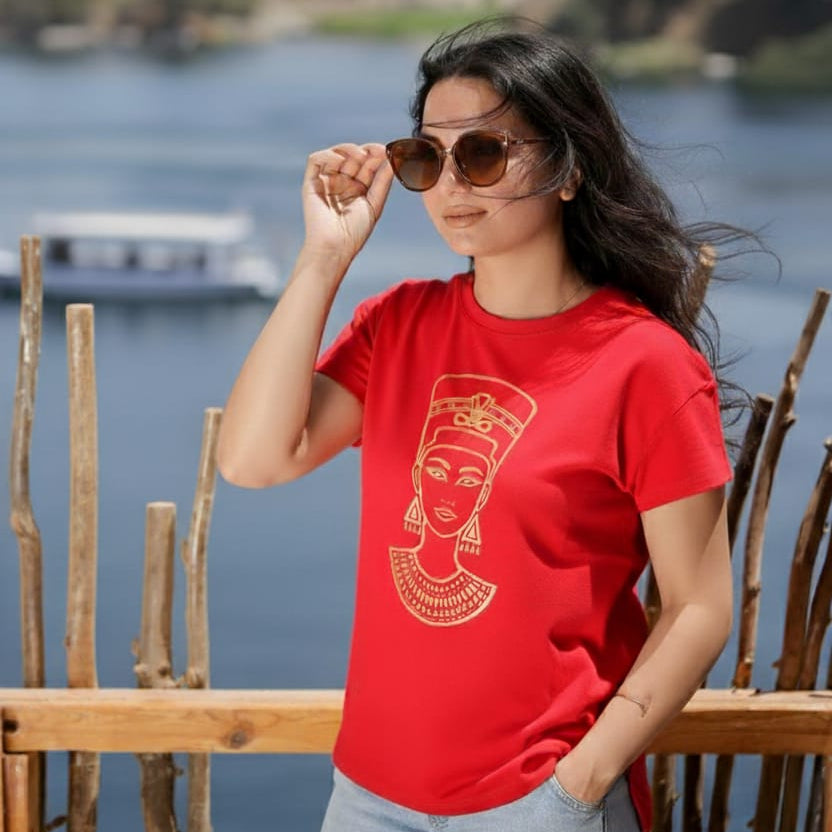 Woman wearing a red t-shirt with a graphic design by a waterfront