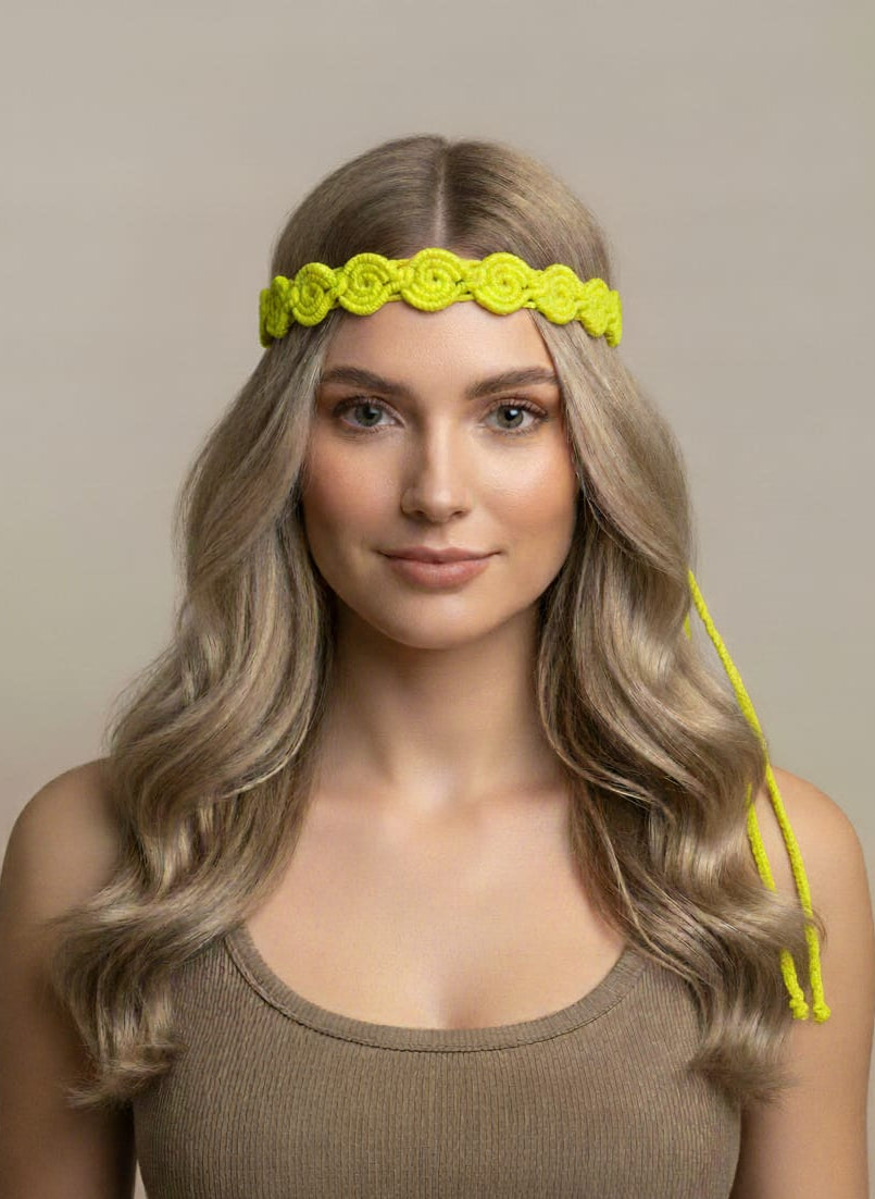 Woman wearing a bright yellow headband with floral design on a neutral background