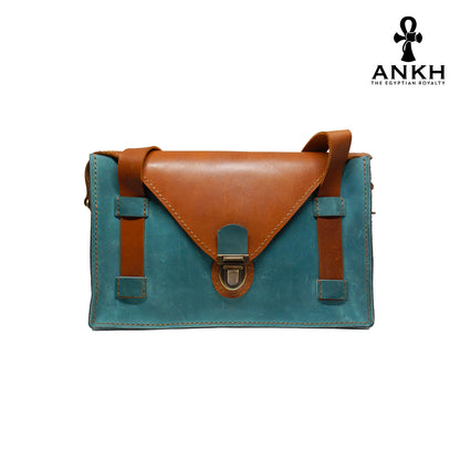 A genuine leather cross bag with handcrafted brass accessories and multiple pockets, displayed on a white background with a black logo of ANKH - The Egyptian Royalty.