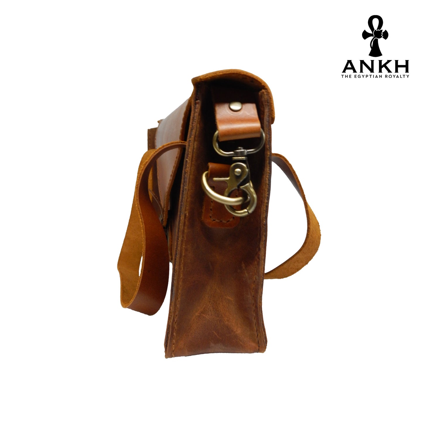 A genuine leather cross bag with handcrafted brass accessories and multiple pockets, displayed on a white background with a black logo of ANKH - The Egyptian Royalty.