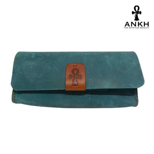 A genuine leather cross bag with handcrafted brass accessories and multiple pockets, displayed on a white background with a black logo of ANKH - The Egyptian Royalty.