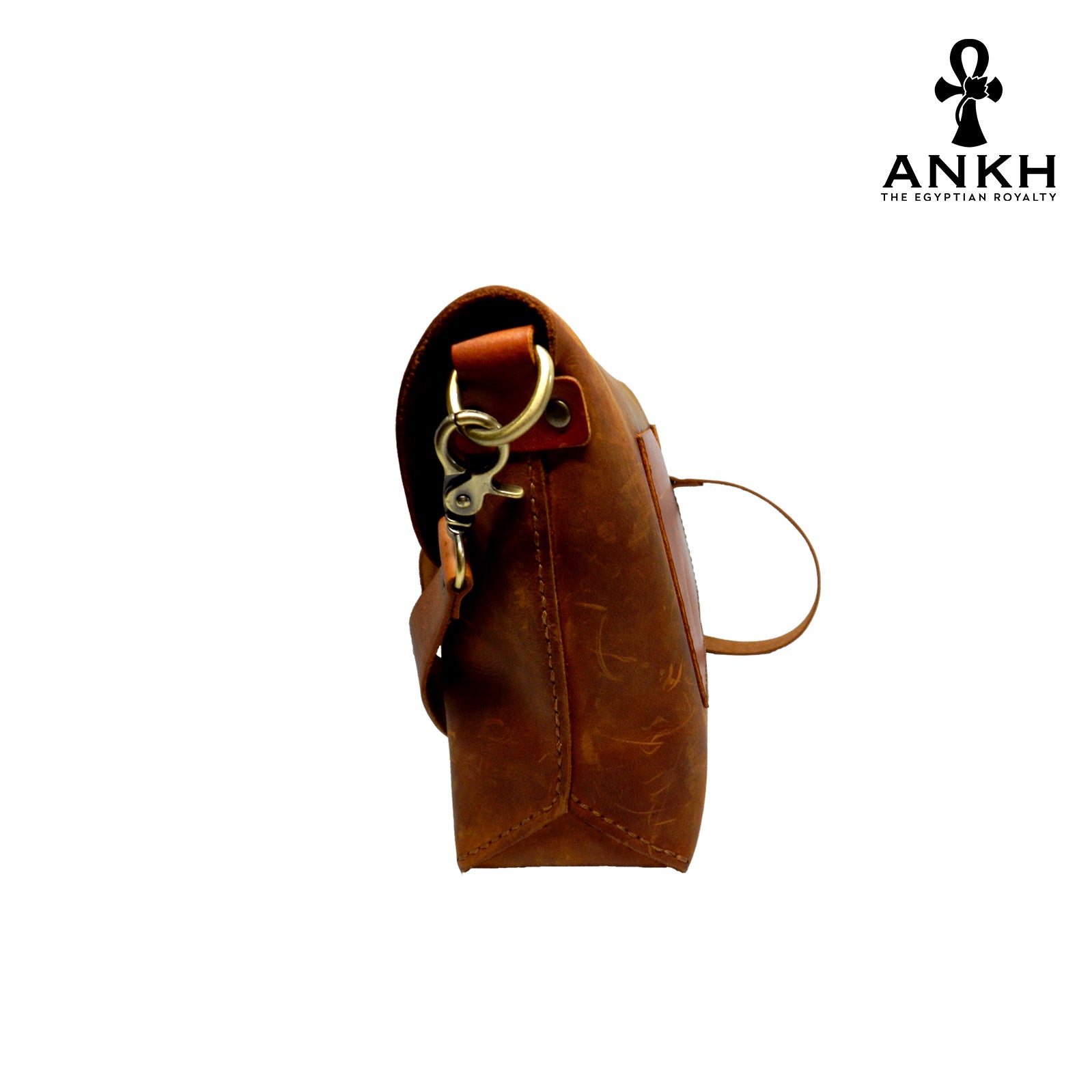 A genuine leather cross bag in red color with handcrafted brass accessories and multiple pockets, displayed on a white mannequin bust with a black logo of ANKH - The Egyptian Royalty.