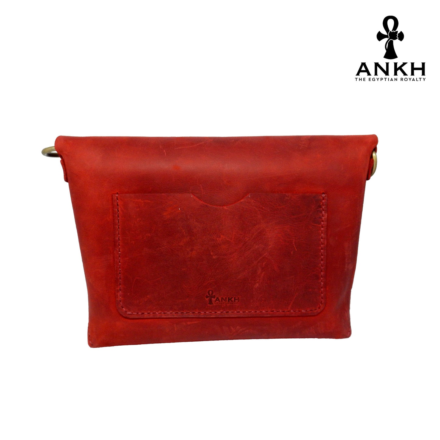 A genuine leather cross bag in red color with handcrafted brass accessories and multiple pockets, displayed on a white mannequin bust with a black logo of ANKH - The Egyptian Royalty.