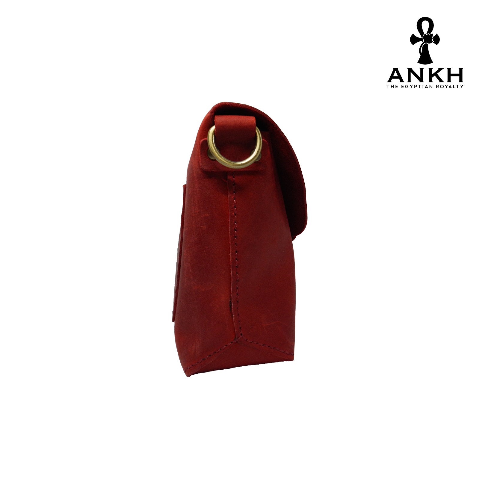 A genuine leather cross bag in red color with handcrafted brass accessories and multiple pockets, displayed on a white mannequin bust with a black logo of ANKH - The Egyptian Royalty.