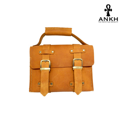 A genuine leather cross bag with handcrafted brass accessories and multiple pockets, displayed on a white background with a black logo of ANKH - The Egyptian Royalty.