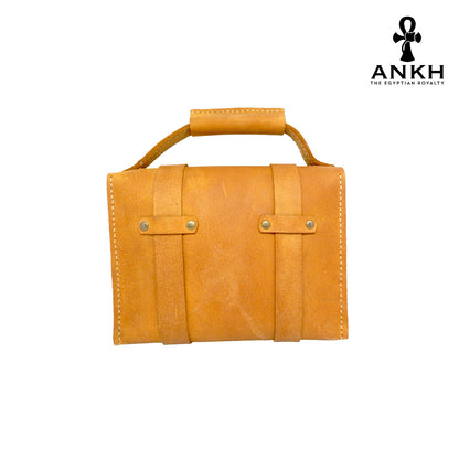 A genuine leather cross bag with handcrafted brass accessories and multiple pockets, displayed on a white background with a black logo of ANKH - The Egyptian Royalty.