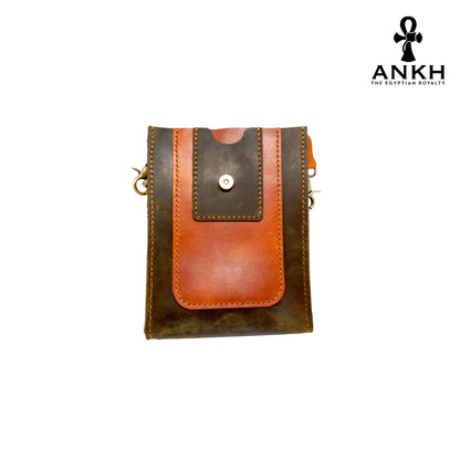 A genuine leather cross bag in navy blue and tan color with handcrafted brass accessories and multiple pockets, displayed on a white mannequin bust with a black logo of ANKH - The Egyptian Royalty.