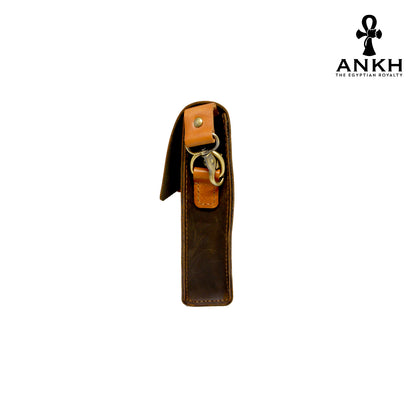 A genuine leather cross bag in navy blue and tan color with handcrafted brass accessories and multiple pockets, displayed on a white mannequin bust with a black logo of ANKH - The Egyptian Royalty.