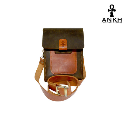 A genuine leather cross bag in navy blue and tan color with handcrafted brass accessories and multiple pockets, displayed on a white mannequin bust with a black logo of ANKH - The Egyptian Royalty.