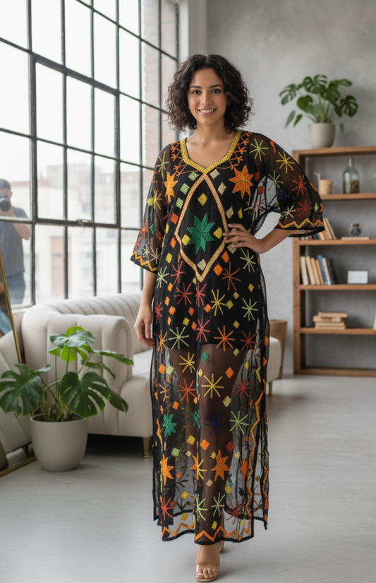 Woman wearing a colorful Tally dress standing in a modern living room.