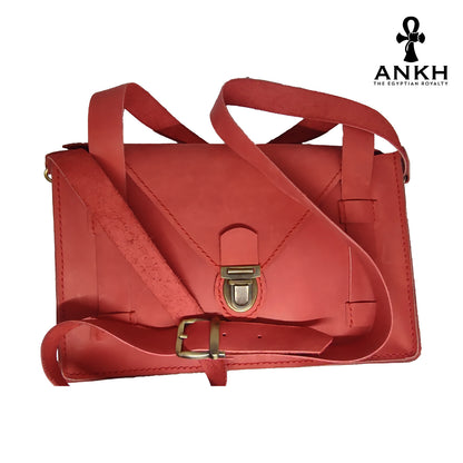 A genuine leather cross bag with handcrafted brass accessories and multiple pockets, displayed on a white background with a black logo of ANKH - The Egyptian Royalty.