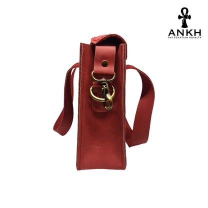 A genuine leather cross bag with handcrafted brass accessories and multiple pockets, displayed on a white background with a black logo of ANKH - The Egyptian Royalty.