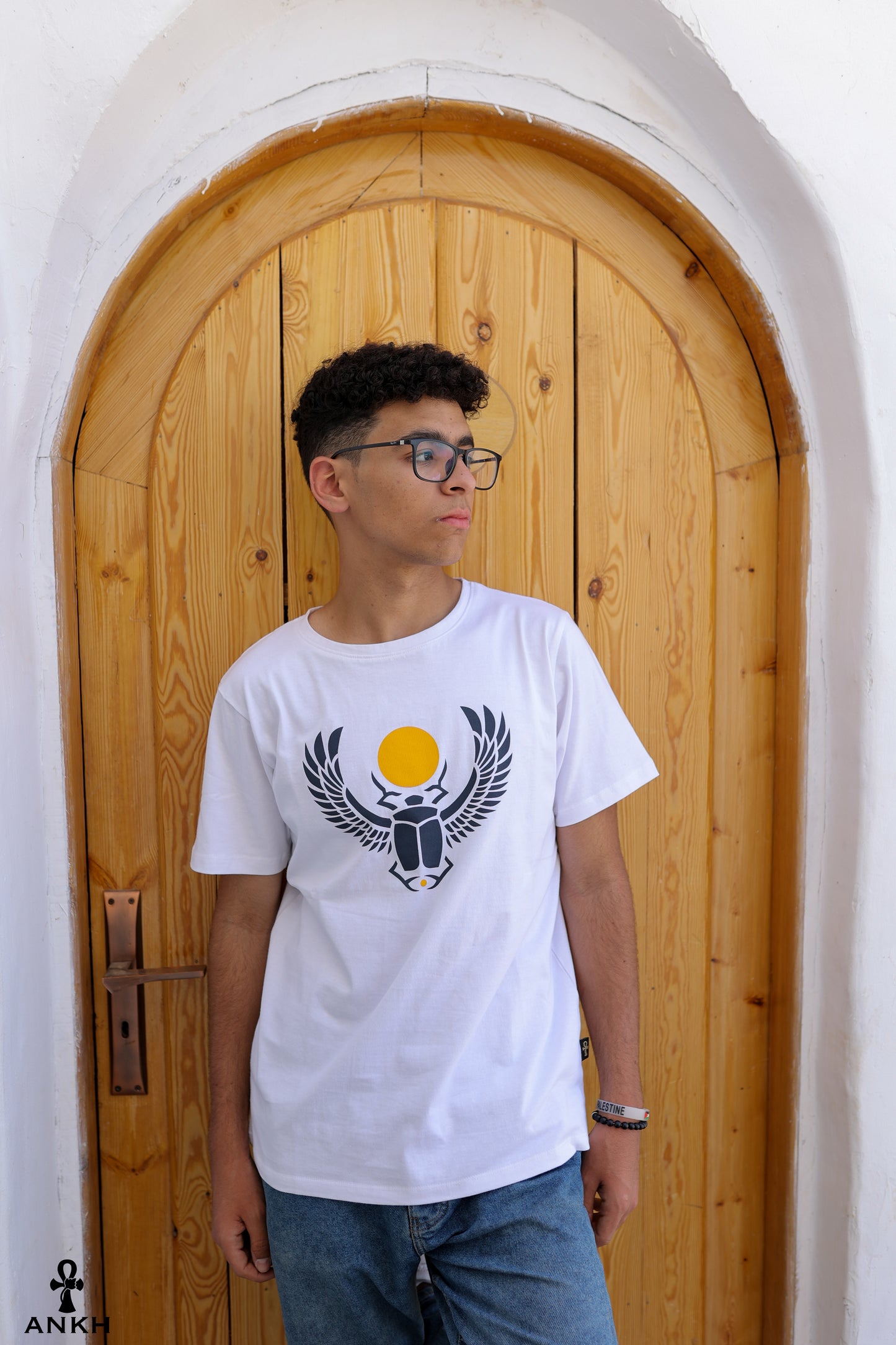 A man wearing a t-shirt with a printed Ancient Egyptian scarab symbol, made from soft 100% Egyptian cotton