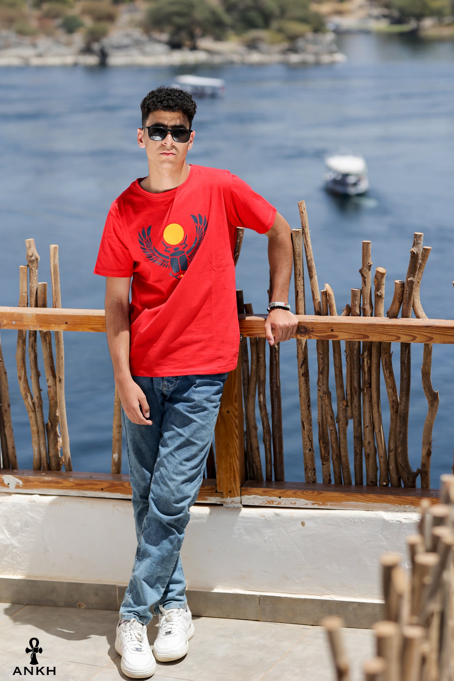 A man wearing a t-shirt with a printed Ancient Egyptian scarab symbol, made from soft 100% Egyptian cotton