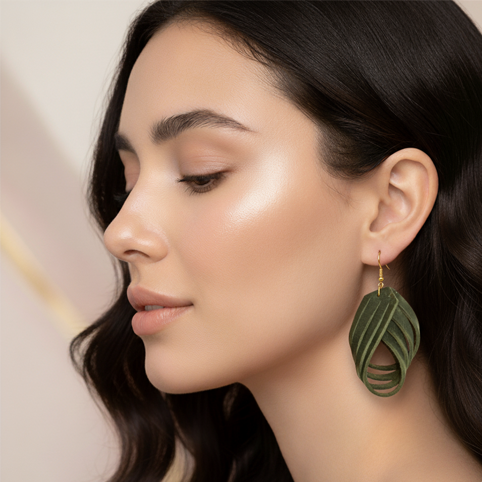 Woman wearing green leaf-shaped earrings with a neutral background