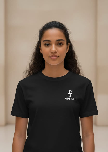 Person wearing a black t-shirt with a symbol and text on a beige background