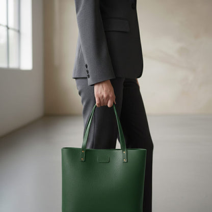 Person holding a green tote bag wearing a dark suit indoors.
