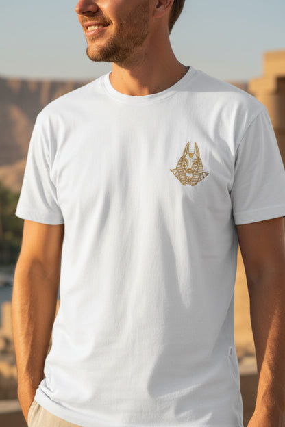 Man wearing a white t-shirt with a gold logo outdoors