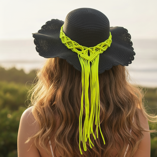 Person wearing a black sun hat with bright green macrame details, standing outdoors.