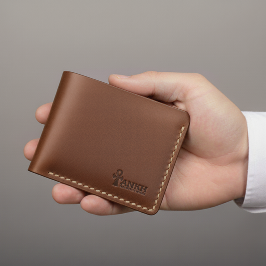 Brown leather wallet held in a hand against a gray background
