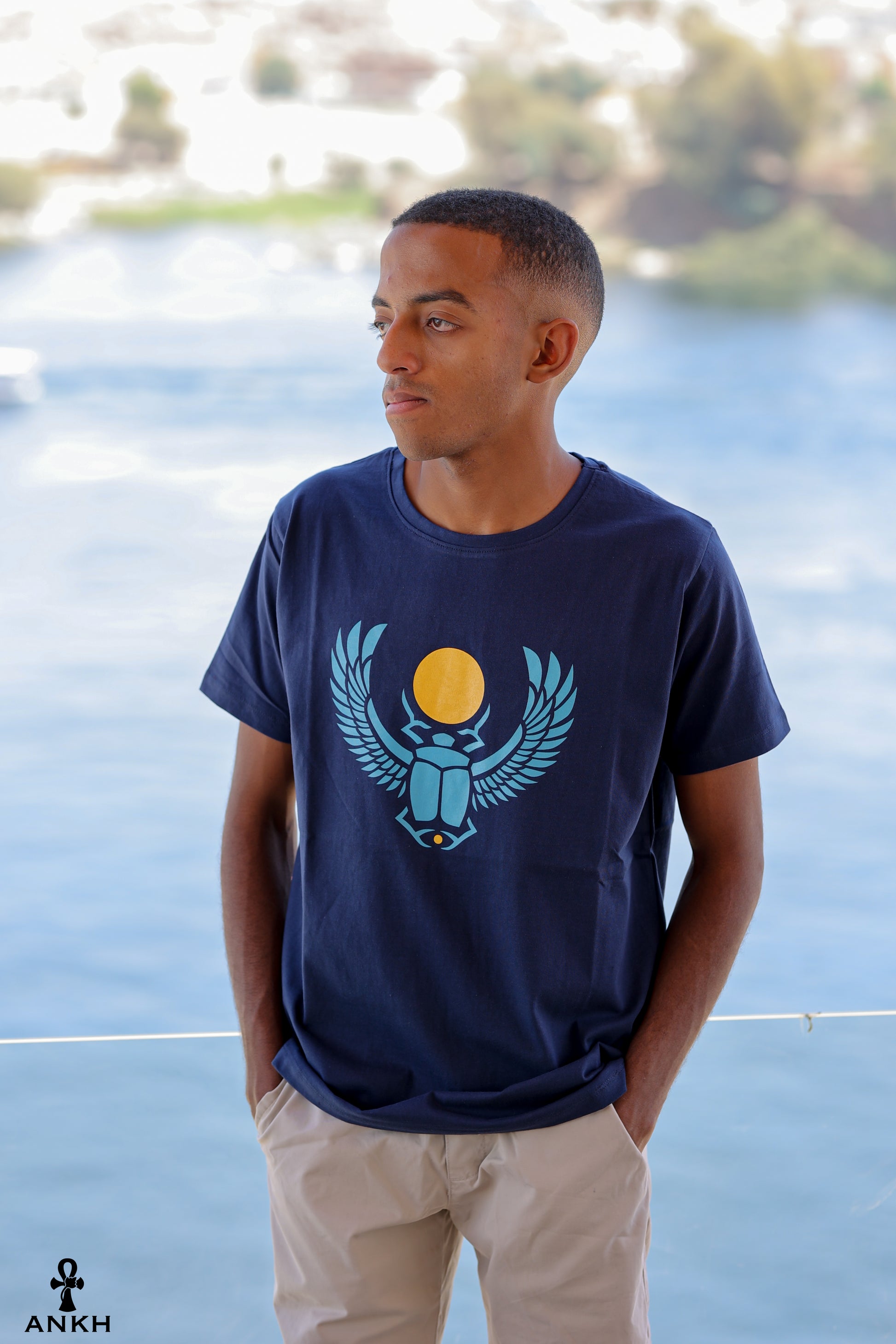 A man wearing a t-shirt with a printed Ancient Egyptian scarab symbol, made from soft 100% Egyptian cotton