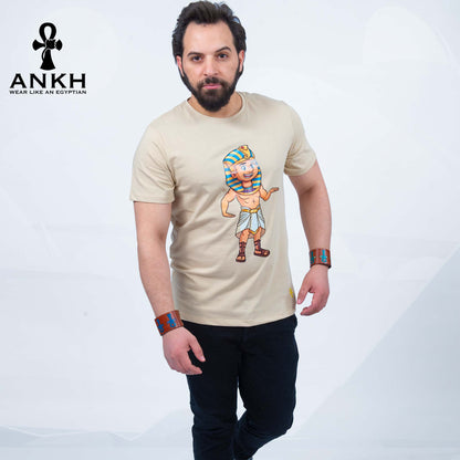 A man wearing an exclusive ‘Royal Tut’ T-shirt from Ankh featuring a playful cartoon depiction of King Tutankhamun printed on premium 100% Egyptian Cotton