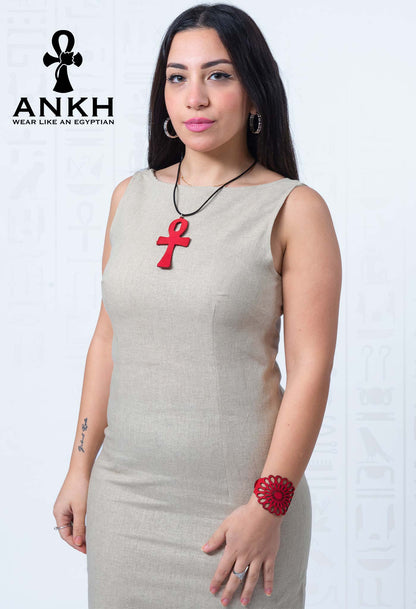 Woman wearing Ankh’s luxurious sleeveless linen dress adorned with iconic red Ankh pendant necklace symbolizing life and immortality