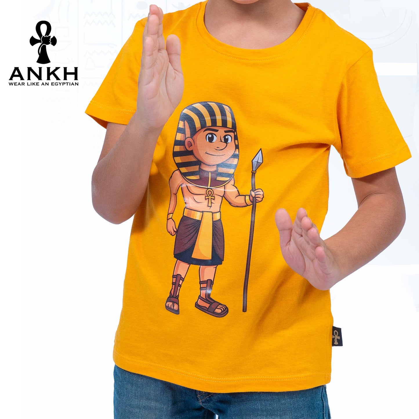 Child wearing a premium white t-shirt adorned with a colorful cartoon depiction of ancient Egyptian King Ahmose, made from luxurious Egyptian Cotton – available exclusively at Ankh