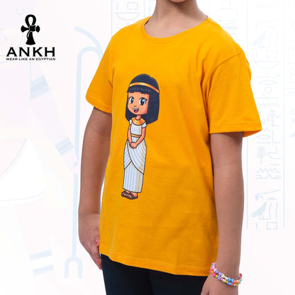 A child wearing Ankh’s bright yellow t-shirt adorned with ‘Anippe’, a cartoony Egyptian girl character printed on premium quality 100% Egyptian cotton - perfect attire reflecting ancient Egyptian culture