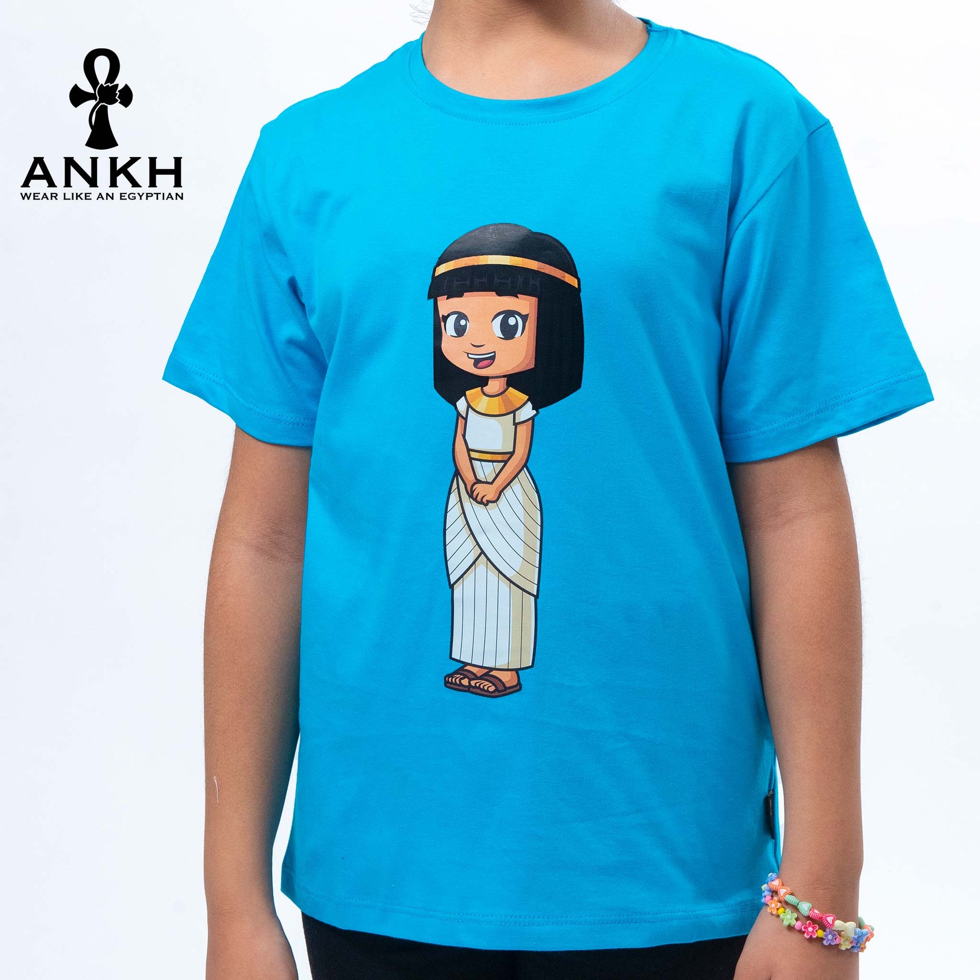 A child wearing Ankh’s bright blue t-shirt adorned with ‘Anippe’, a cartoony Egyptian girl character printed on premium quality 100% Egyptian cotton - perfect attire reflecting ancient Egyptian culture