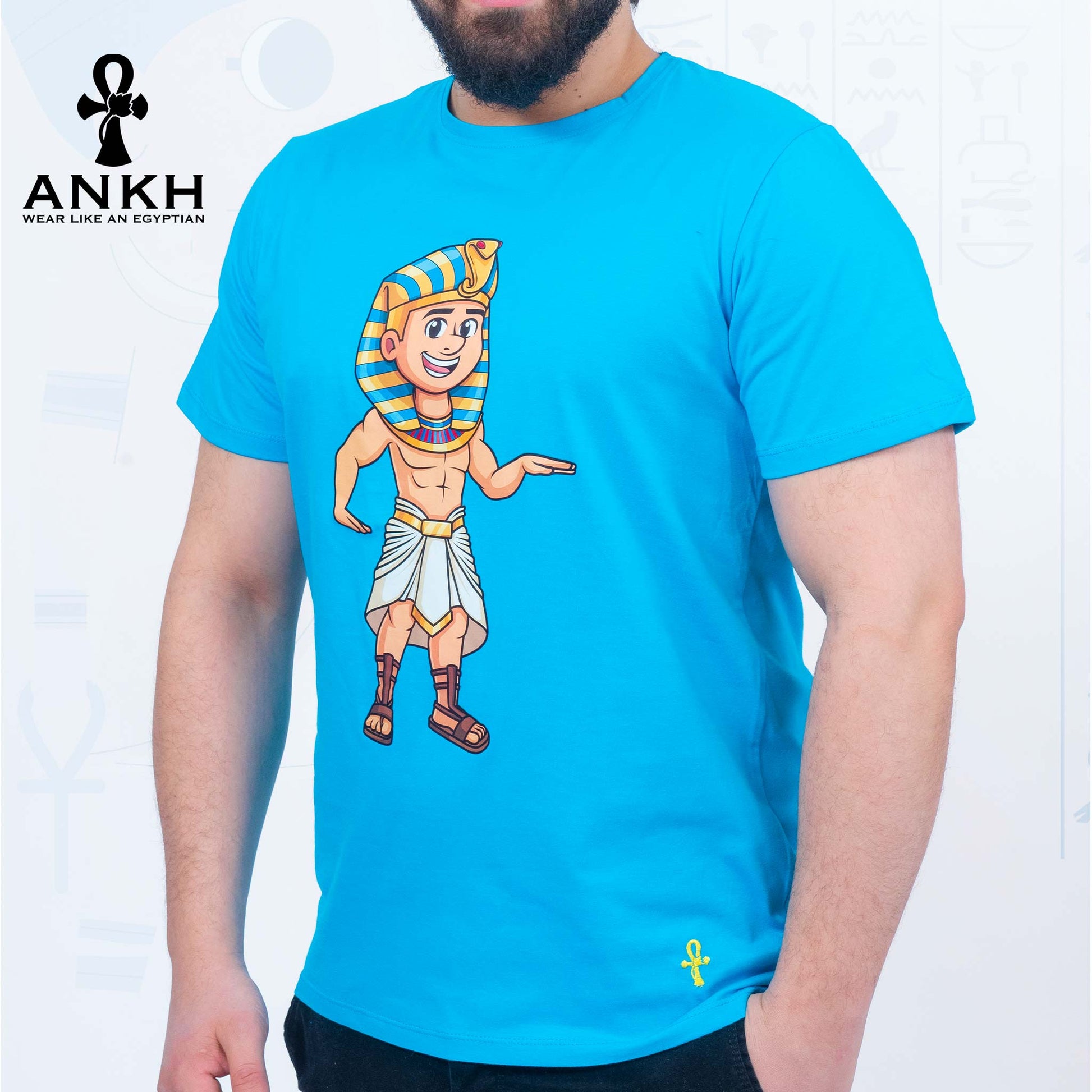 A man wearing an exclusive ‘Royal Tut’ T-shirt from Ankh featuring a playful cartoon depiction of King Tutankhamun printed on premium 100% Egyptian Cotton